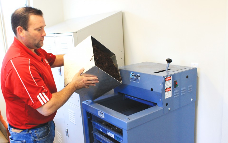 Hughes Mulch employee using quality control equipment